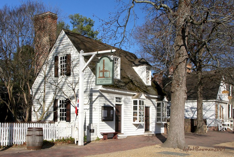 White two-story house with a picket fence